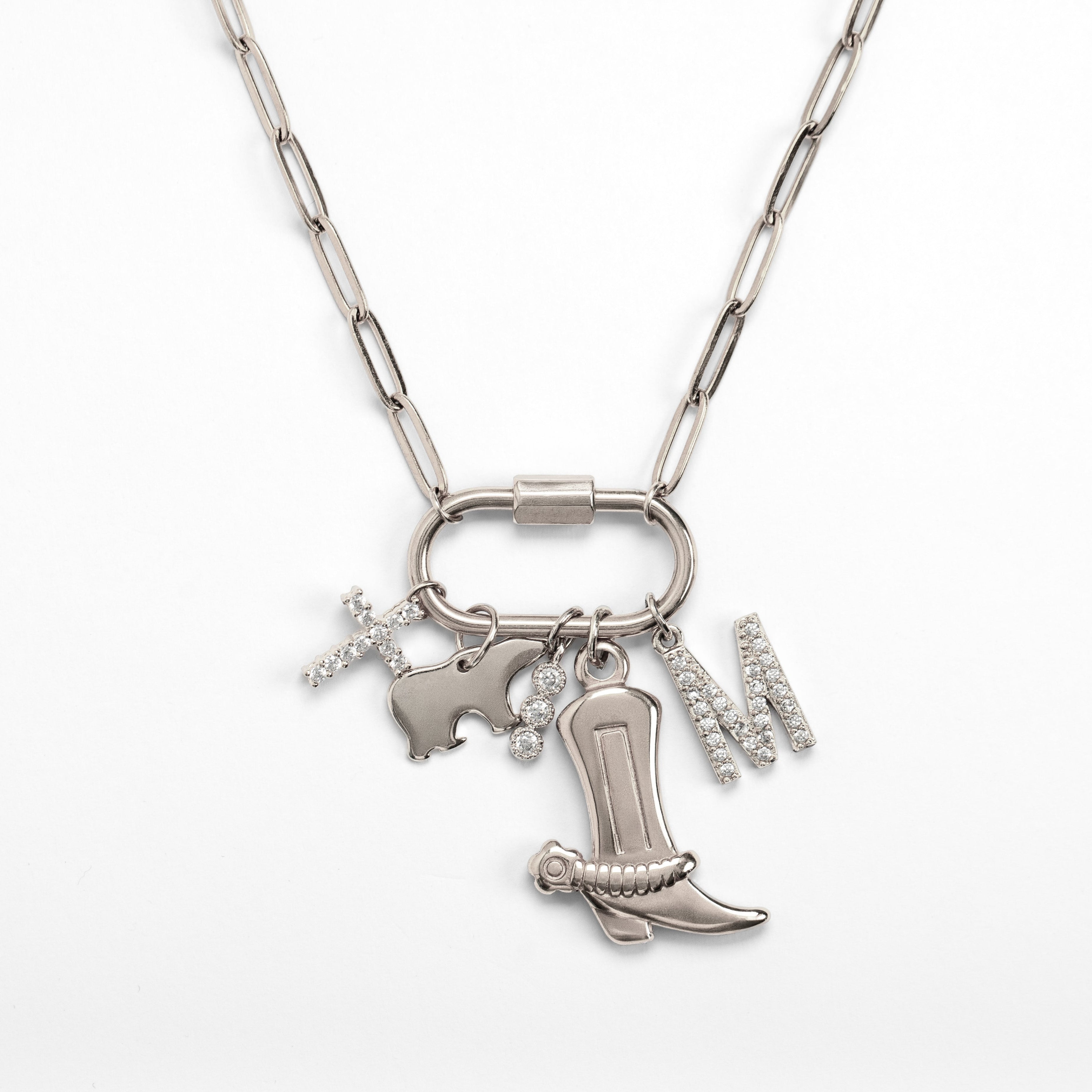 Silver necklace with cowboy boot and heart charm on a white background