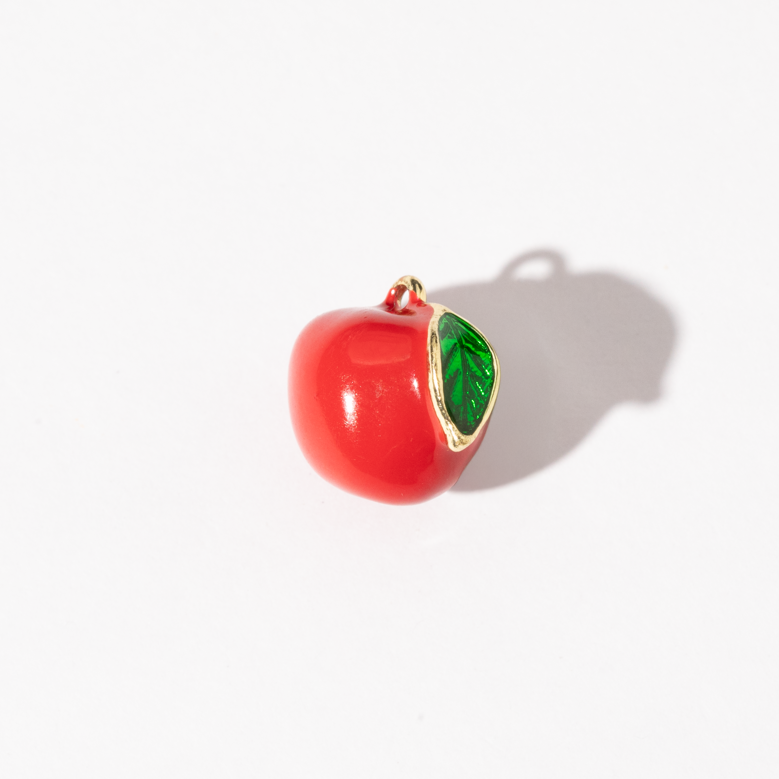 A gold-plated stainless steel charm shaped like a red apple with a bright green leaf.