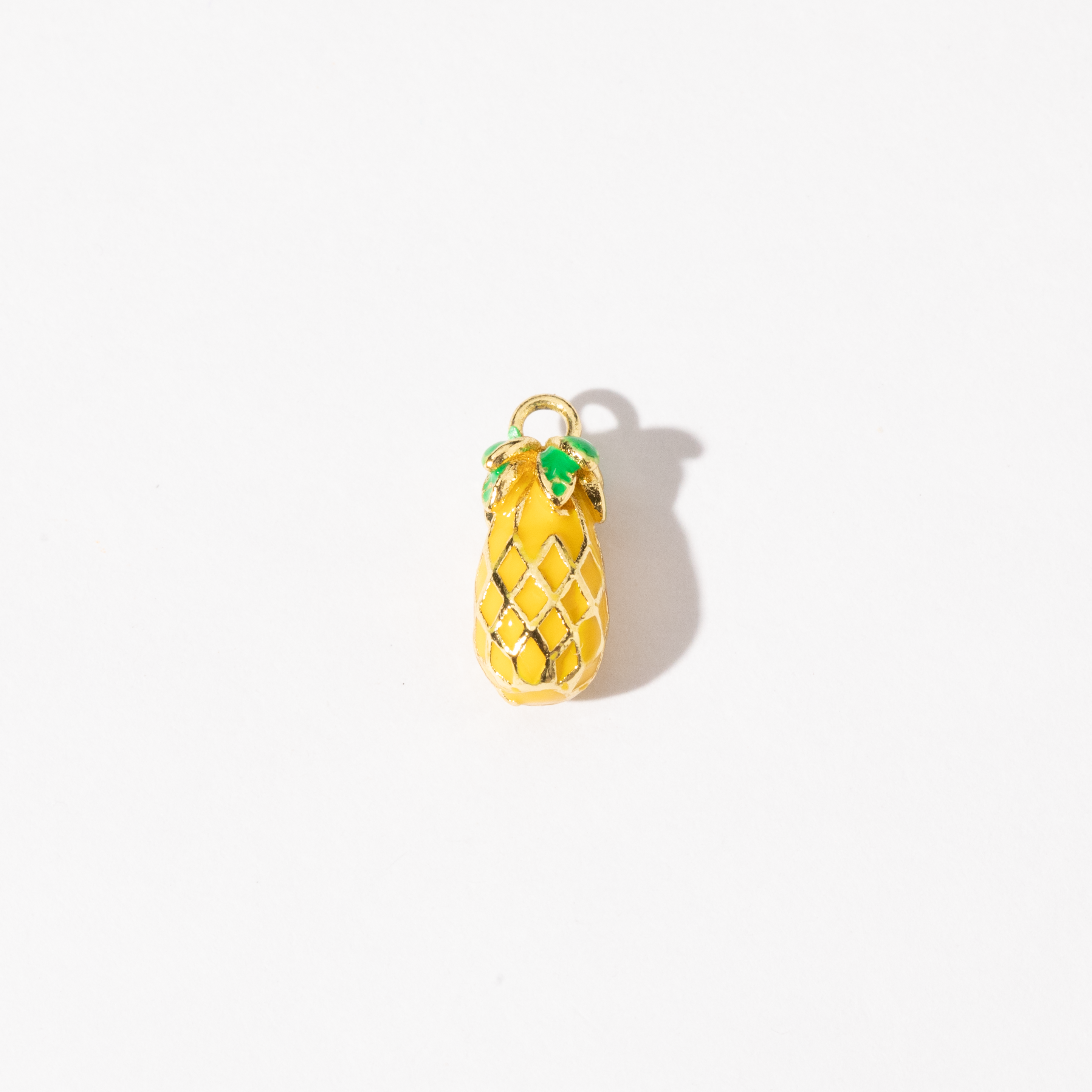 A gold-plated personalized stainless steel charm with a sculpted pineapple design, complete with delicate lattice detailing and bright green accents.