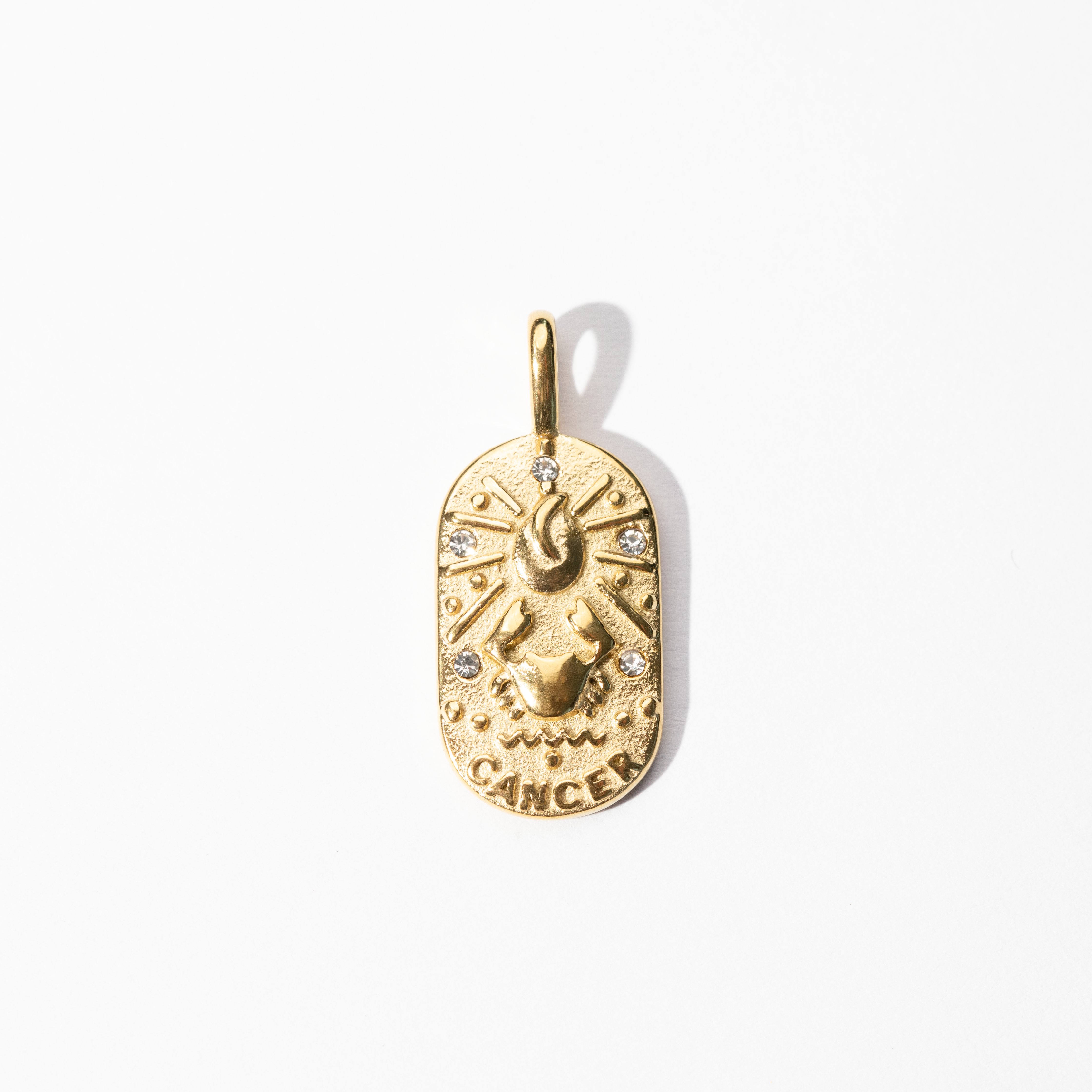 A gold-colored metal medallion charm with a Cancer zodiac symbol, featuring intricate celestial design.