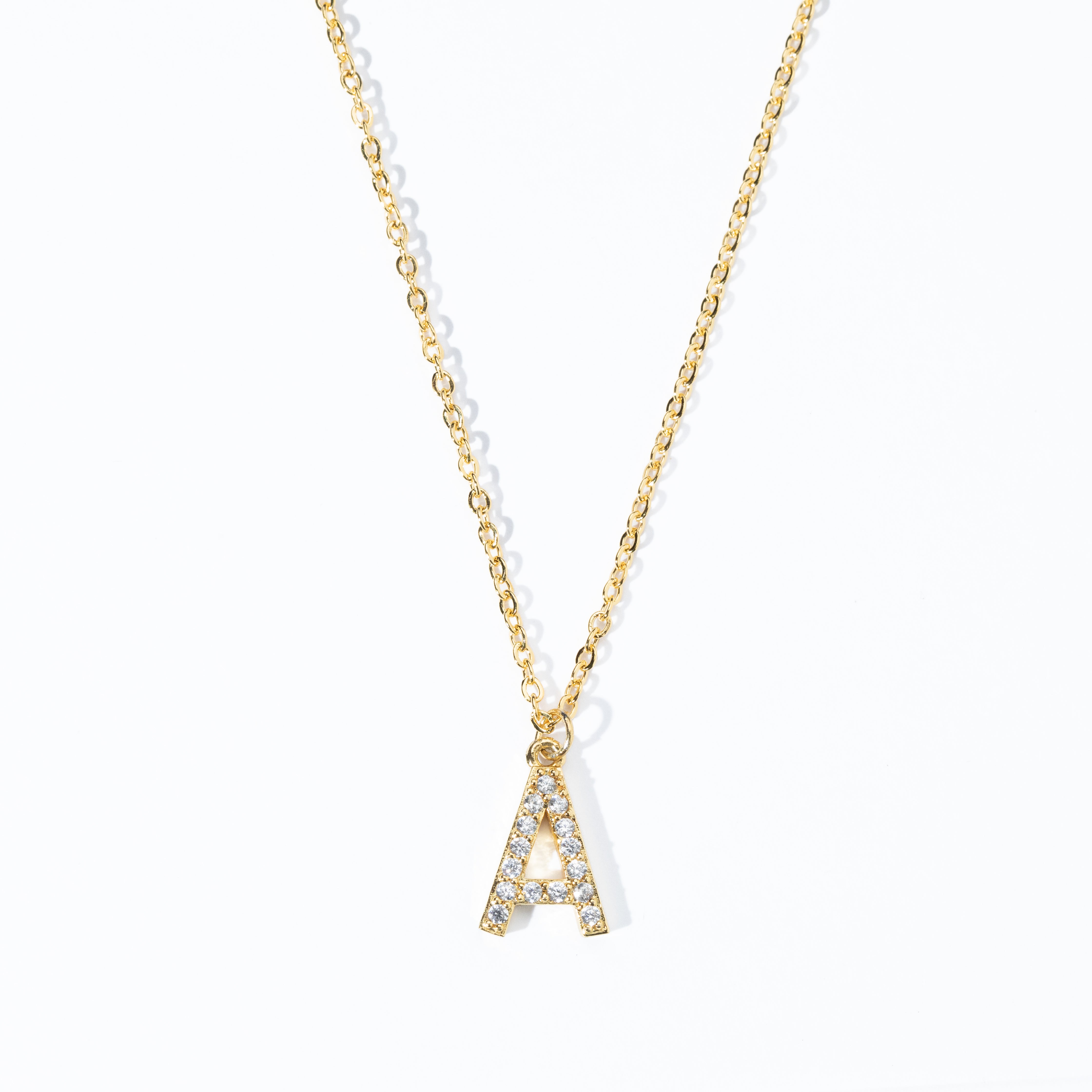 A gold-colored necklace with personalized initial displaying the necklace with a single letter 'A' pendant adorned with clear stones on a white background.