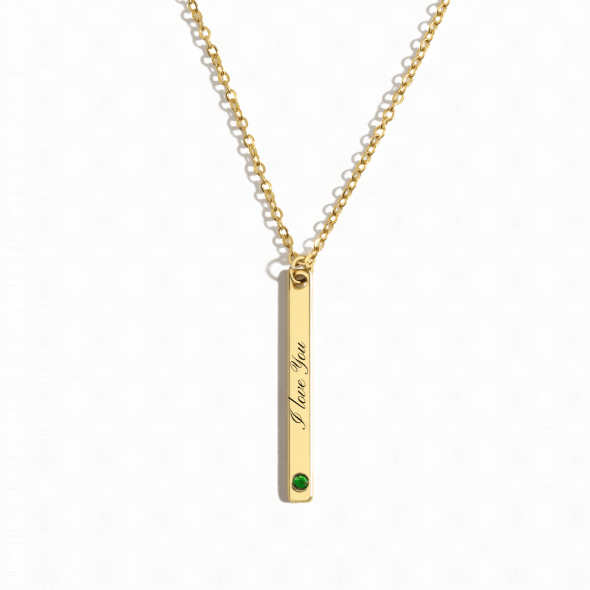 Personalized gold vertical bar necklace featuring a custom engraving and a birthstone accent at the bottom, hanging from a delicate gold chain.