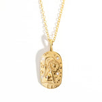 A gold-colored zodiac medallion necklace with a chain.