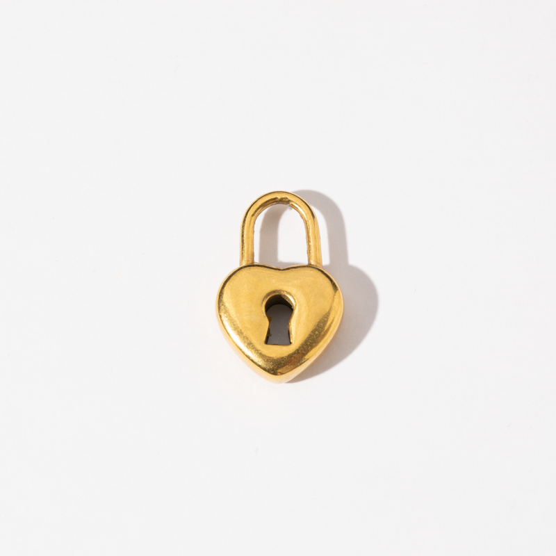 A gold-colored heart-shaped padlock charm on a white background.