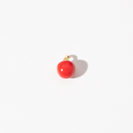 A gold-plated stainless steel charm with a smooth, rich red surface and golden accents, resembling a cherry tomato.