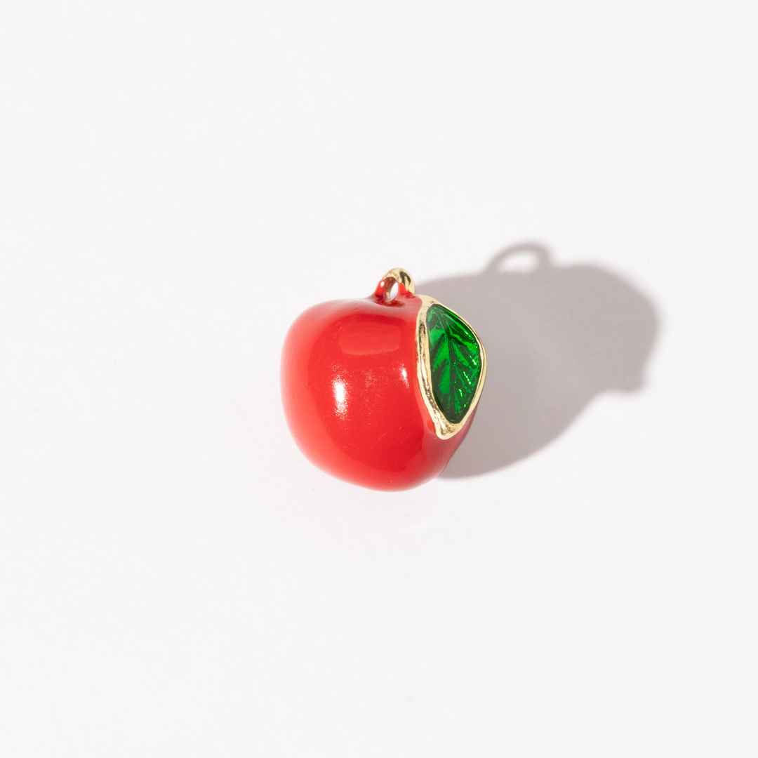A gold-plated stainless steel charm shaped like a red apple with a bright green leaf.