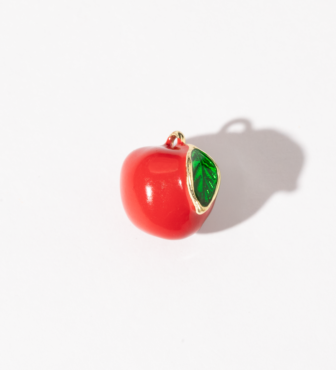 A gold-plated stainless steel charm shaped like a red apple with a bright green leaf.