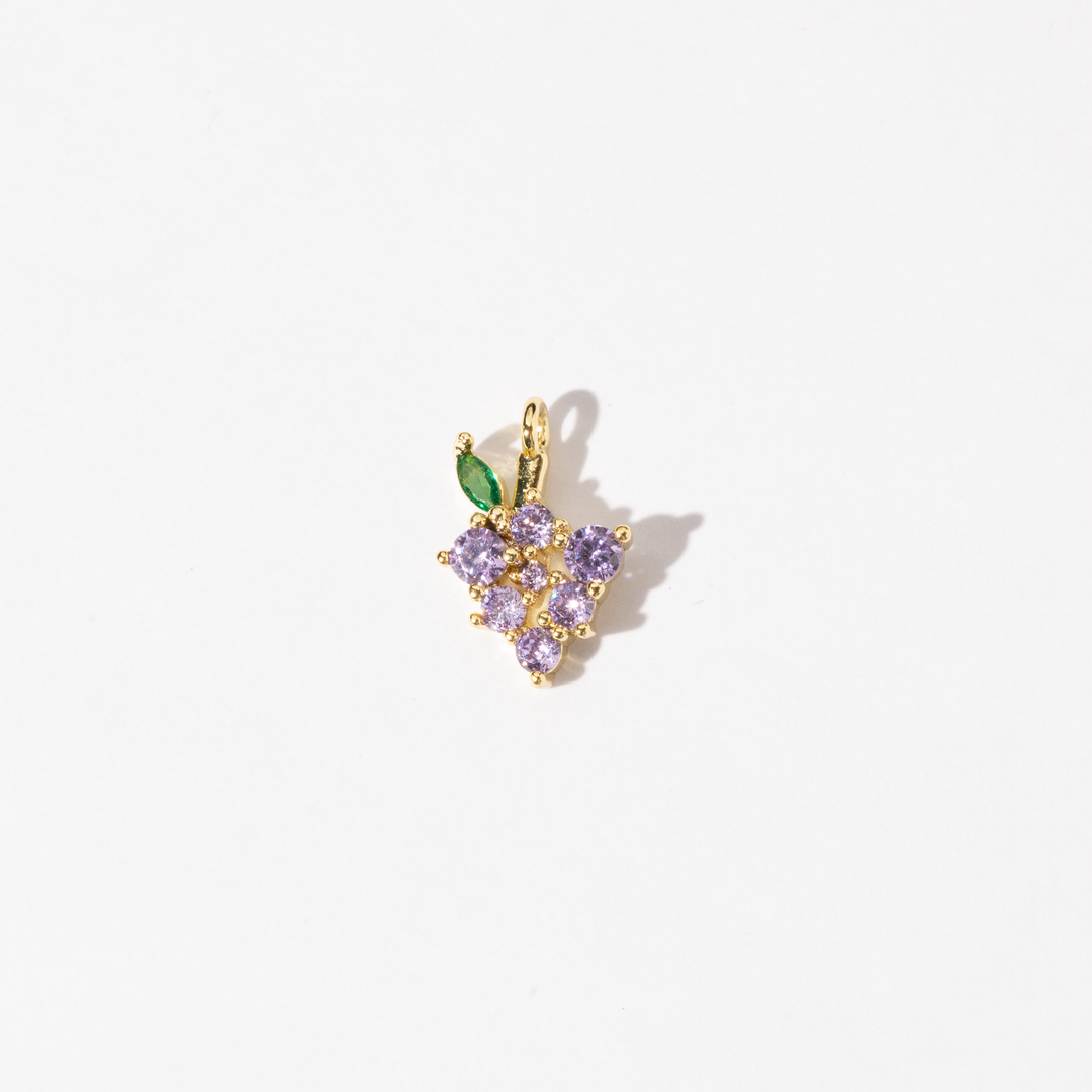 A customized gold plated stainless steel charm featuring a cluster of light purple zirconia stones with a green leaf accent.