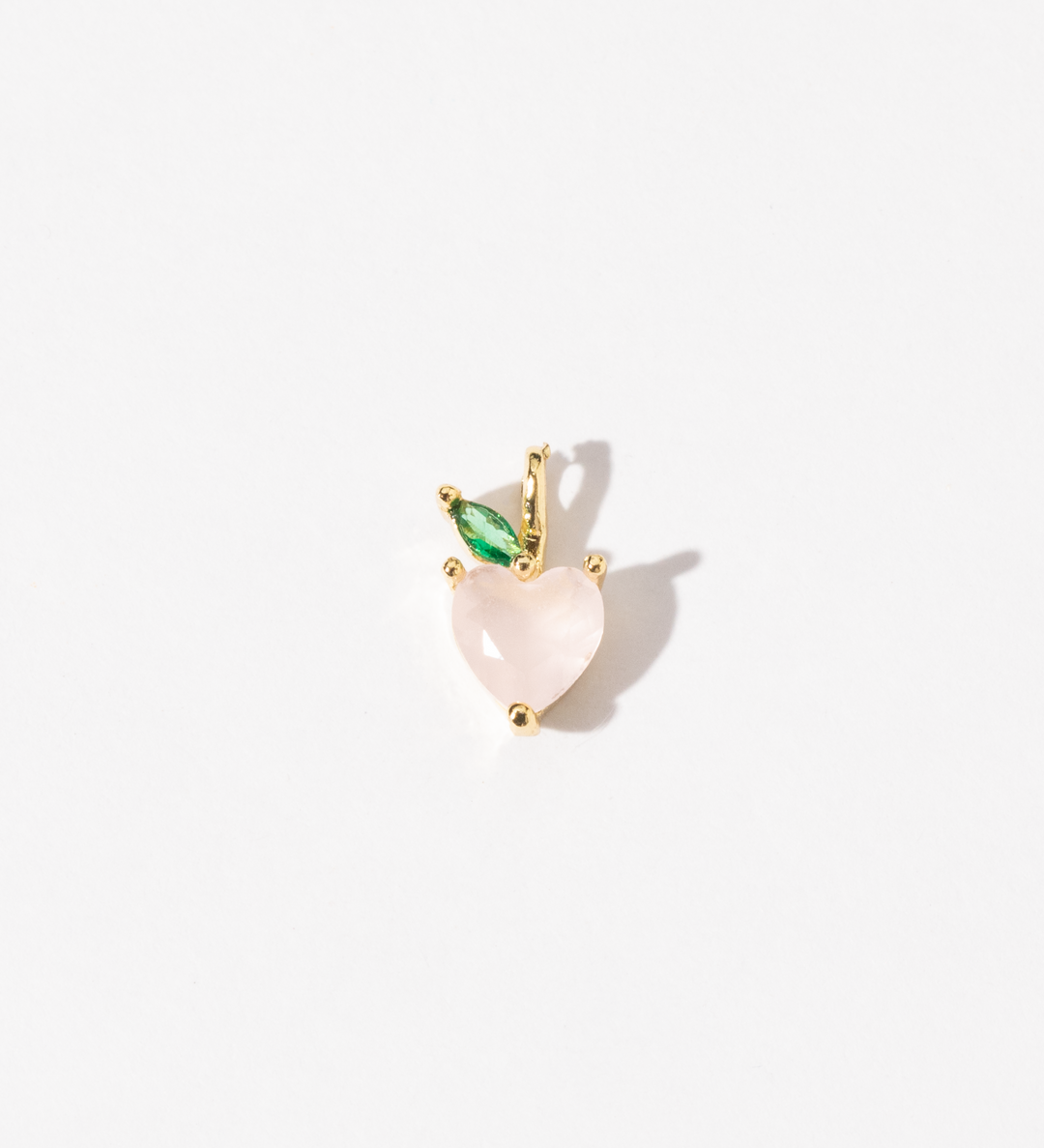 A gold plated stainless steel handmade charm with a soft pink heart-shaped peach and a single green zirconia leaf.