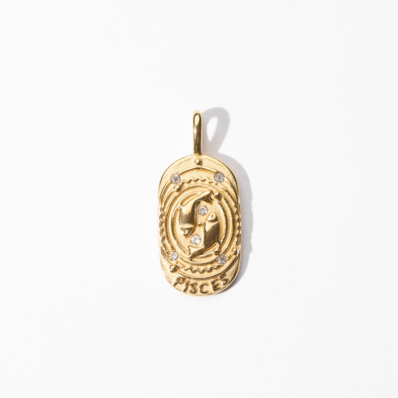 A gold-colored metal medallion charm with the Pisces symbol and small embellishments