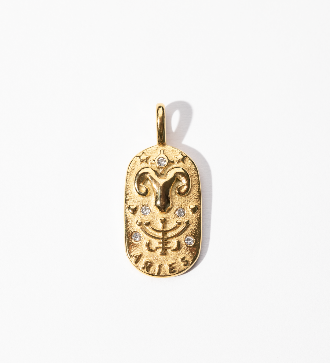 A gold-colored metal Aries medallion charm with intricate designs and small decorative stones.