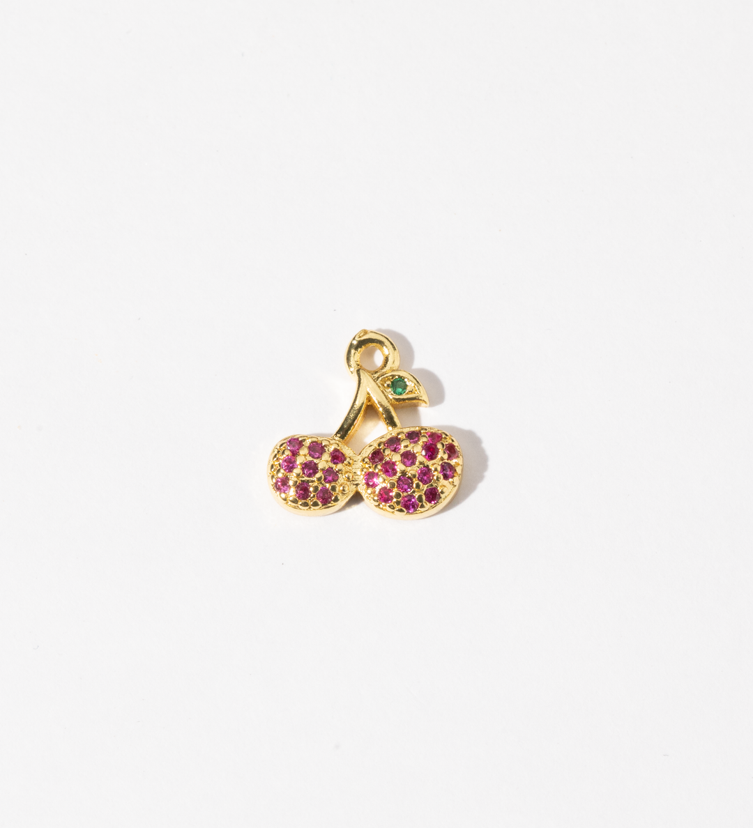 A custom made gold plated stainless steel charm in the shape of two cherries with red zirconia paving and a green gem leaf.