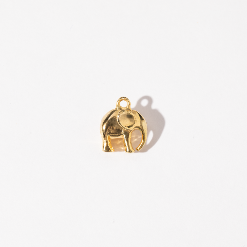 A gold-colored metal charm shaped like an elephant.
