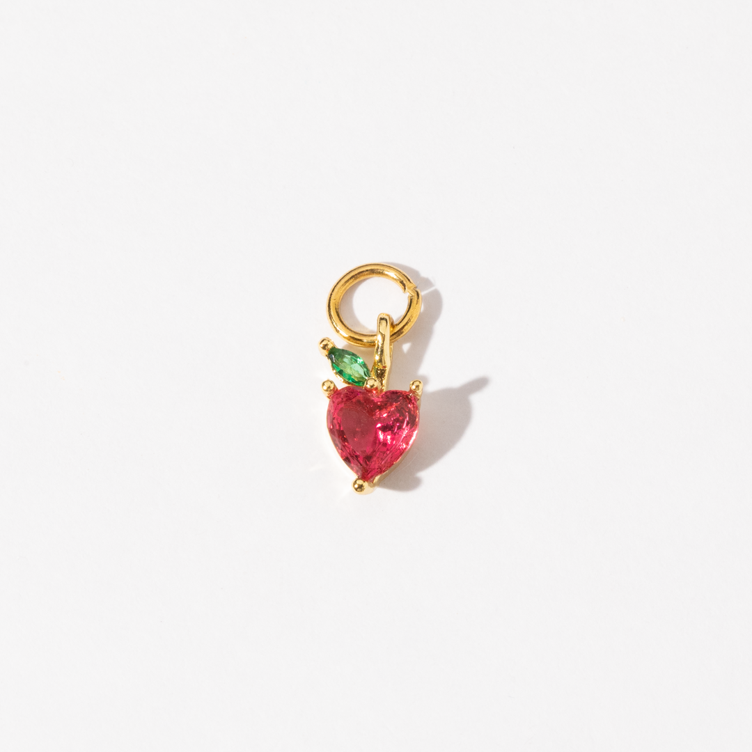 A gold plated personalized strawberry stainless steel charm featuring a heart-shaped red zirconia stone with a green marquise leaf accent.