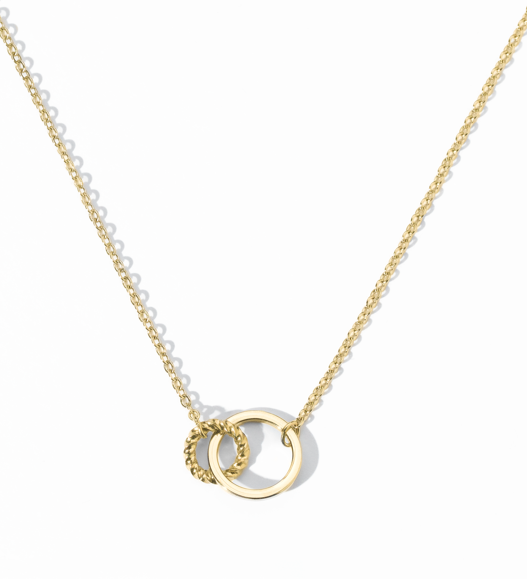 A gold-colored necklace with two interlocking rings on a white background.