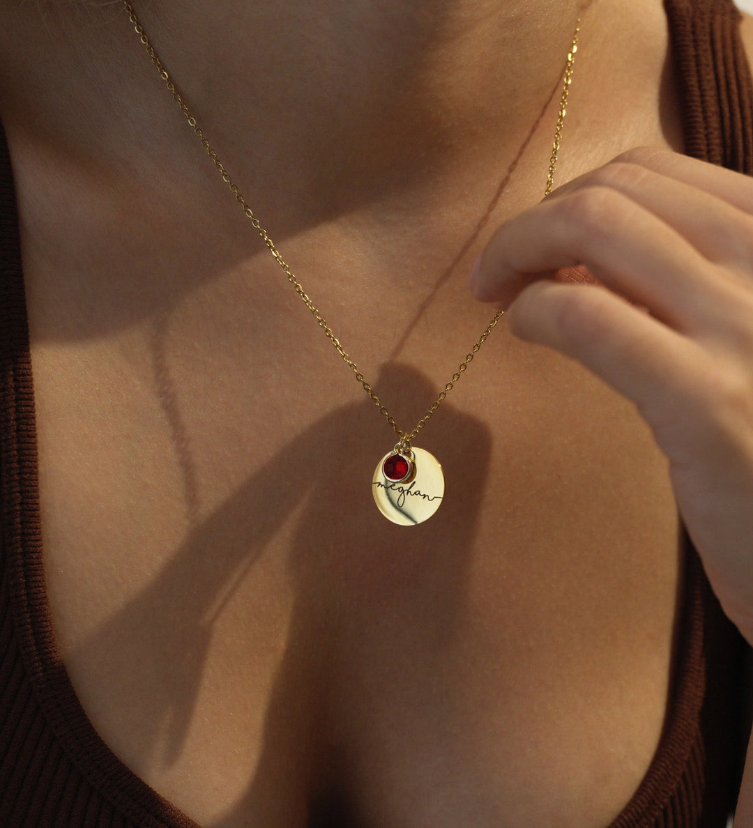 Gold necklace with a Personalized pendant worn by a person against a neutral background