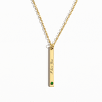 Personalized gold vertical bar necklace featuring a custom engraving and a birthstone accent at the bottom, hanging from a delicate gold chain.
