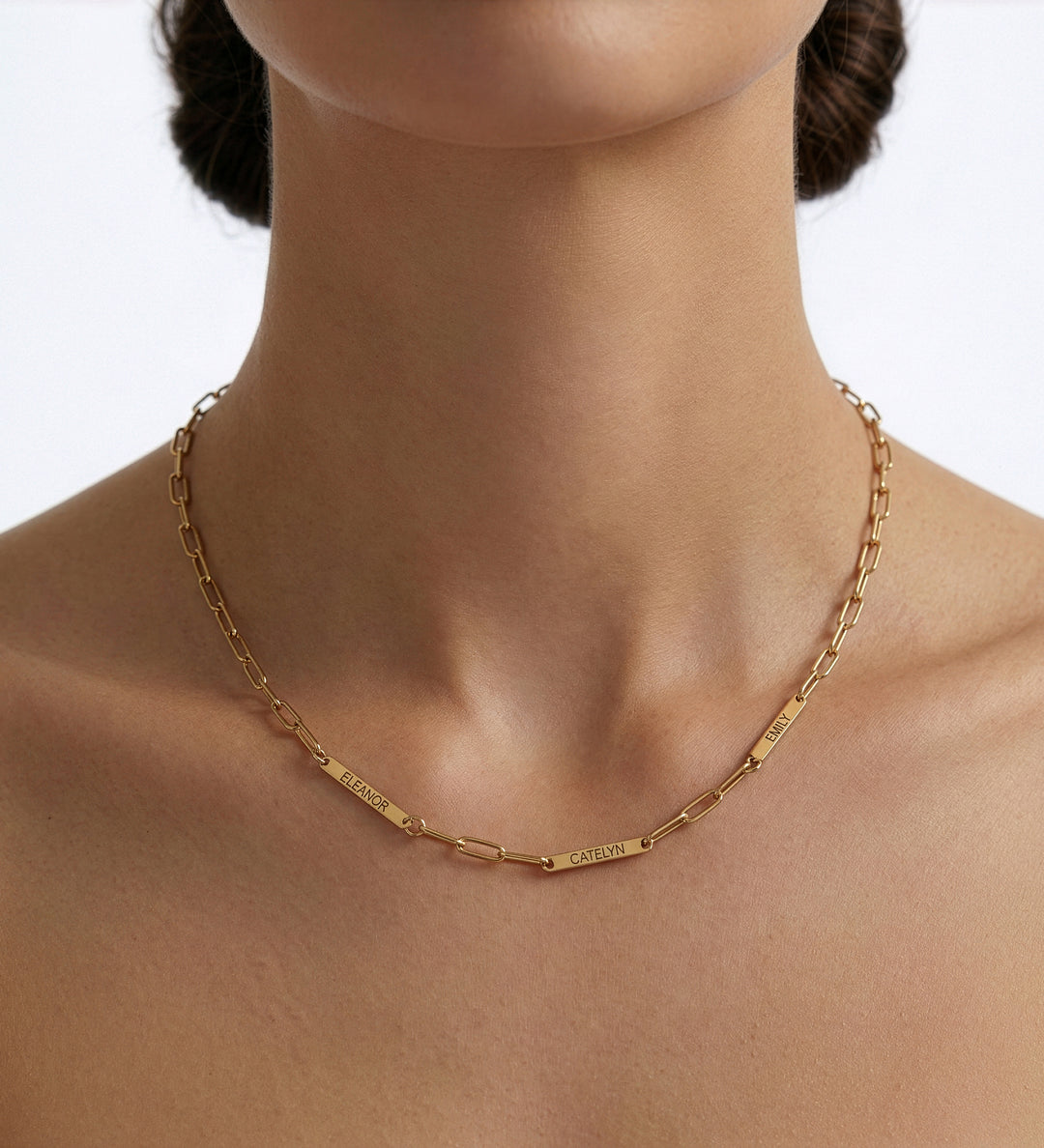 Gold chain necklace on a model against a white background