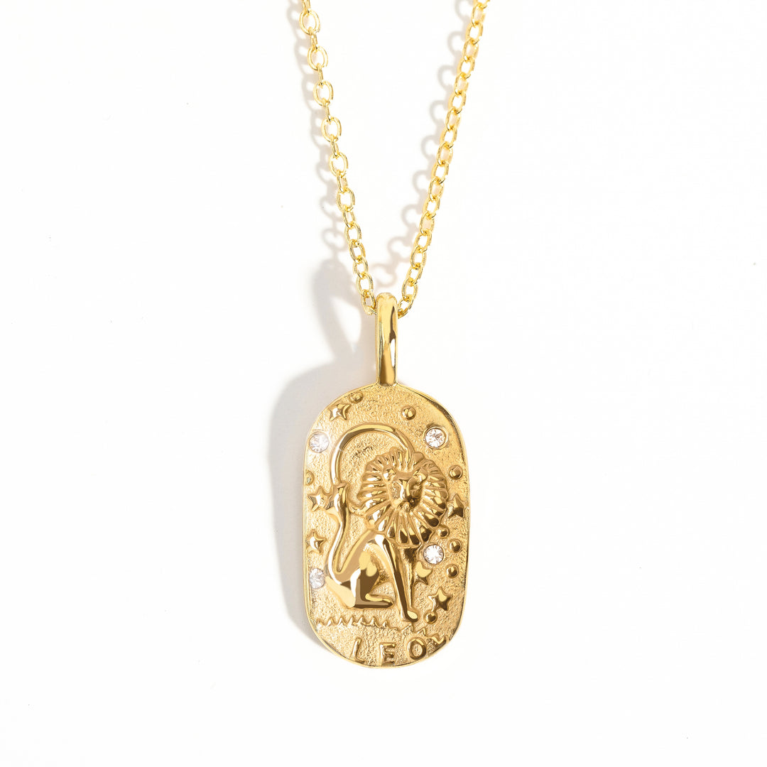 A gold-colored zodiac medallion necklace with a chain.
