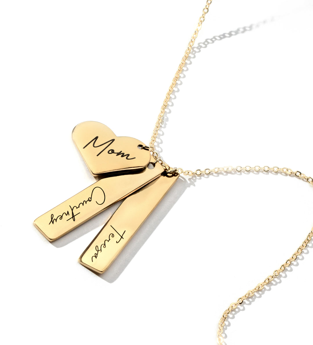 A gold-plated necklace with a vertical heart cutout charm and two engraved bars on a cable chain.